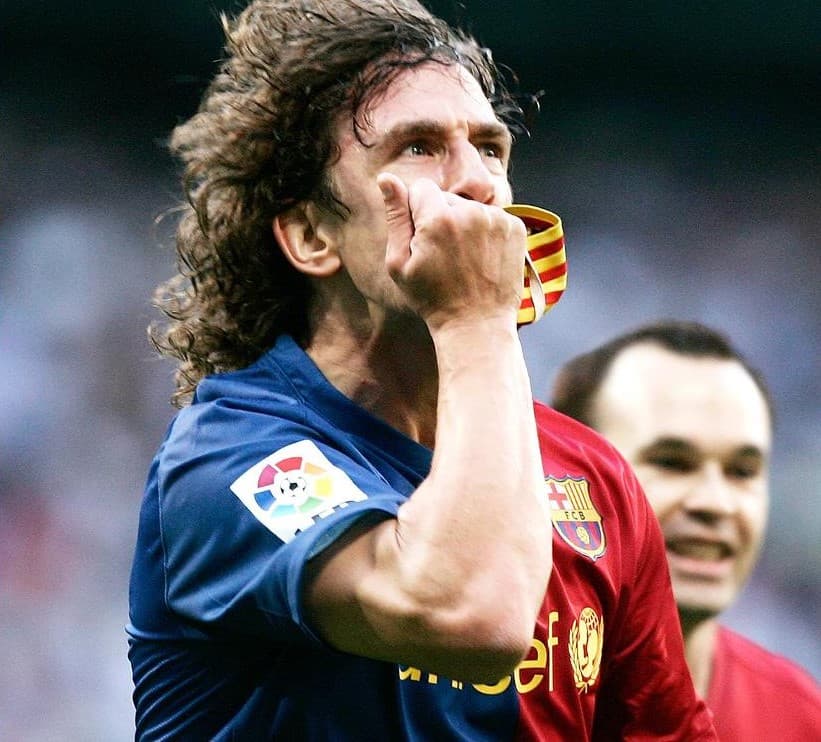 Carlos Puyol celebrates an El Clasico goal by kissing his Catalan-flag-colored captain's band
